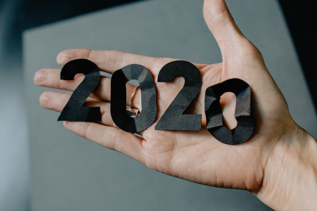 Hands displaying paper numbers showing 2020