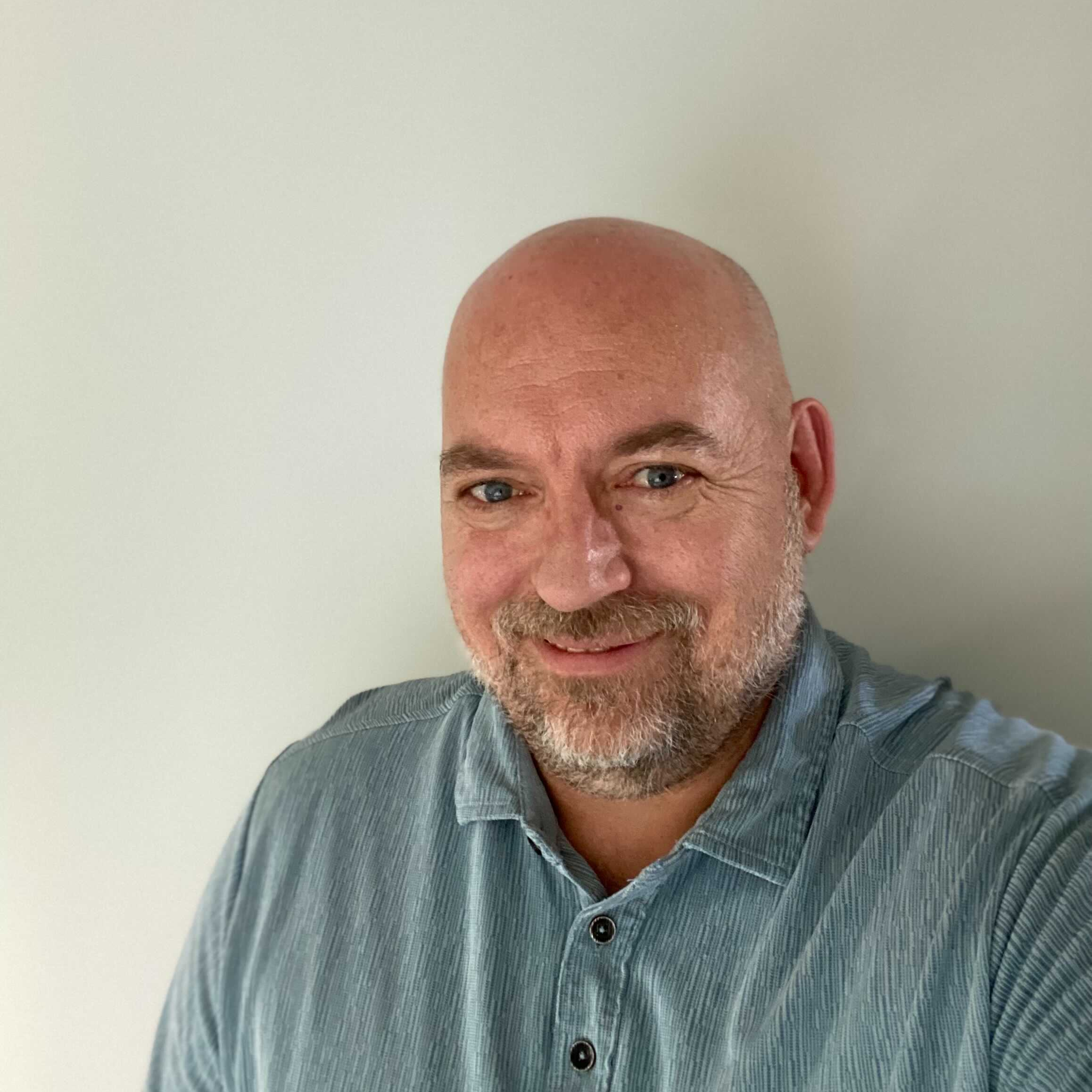 Pressbooks team member John McLeod wearing a blue button up shirt