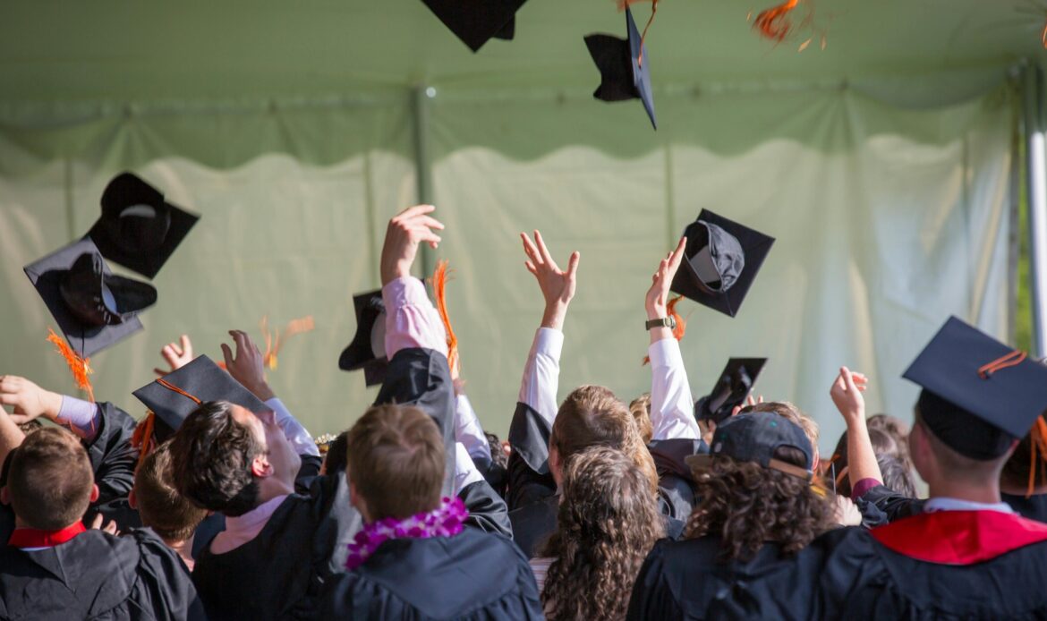 Students graduating college and throwing their caps in the air