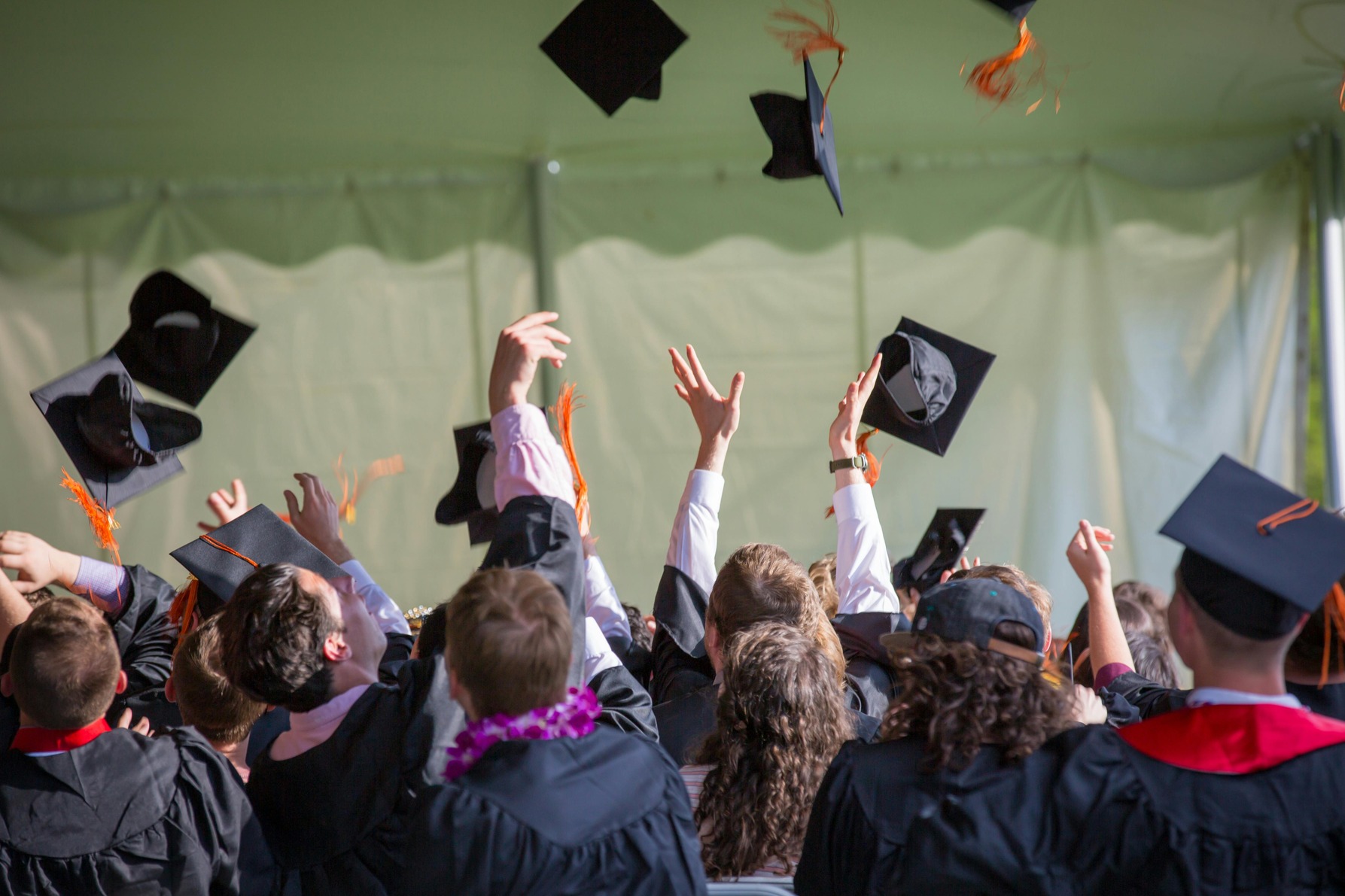 Students graduating college and throwing their caps in the air