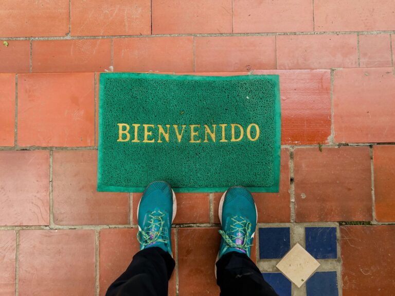 Somone standing in front of a welcome mat that reads 'Bienvenedo'