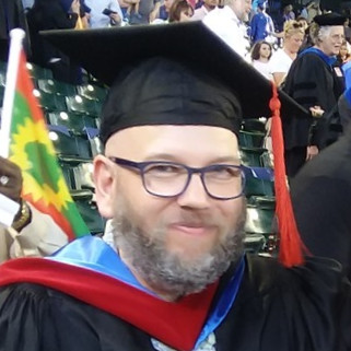instructor wearing graduation cap and gown