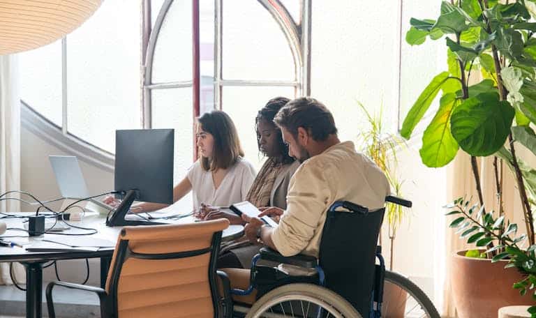 Diverse team working together in a modern office setting with inclusive collaboration.