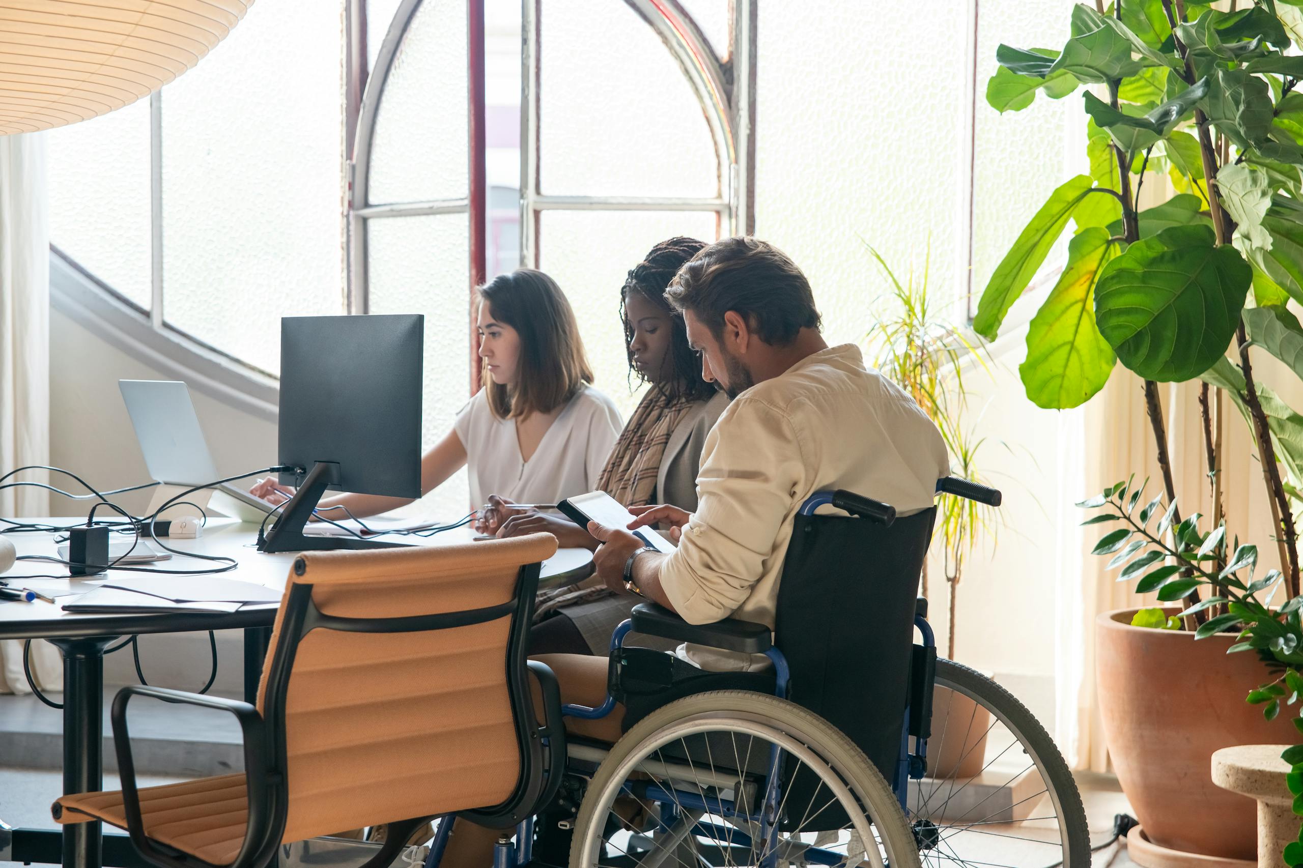 Diverse team working together in a modern office setting with inclusive collaboration.