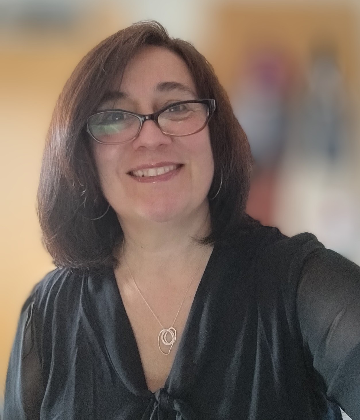 woman smiling with black shirt and black rimmed glasses